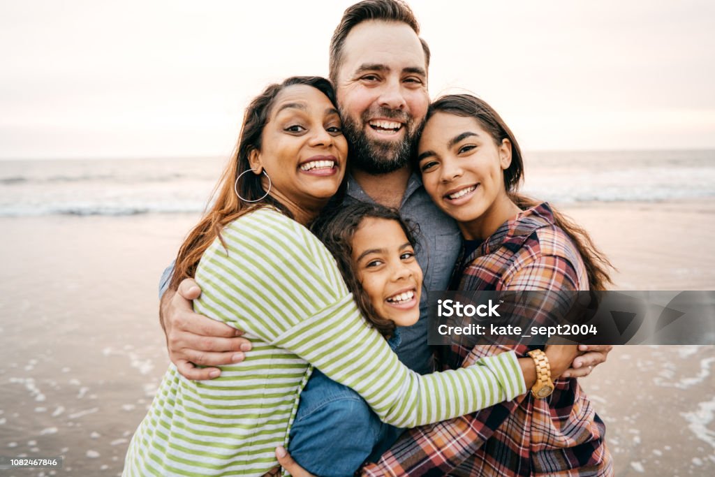 Smiling parents with two children on the beach